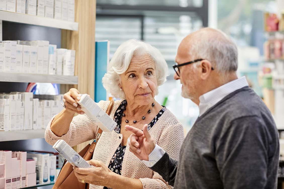 A retired couple contemplating inflation in a drug store