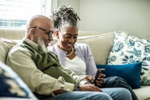 A couple using retirement planning apps on their couch
