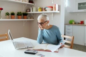 Woman looking at homeowners insurance policy on laptop