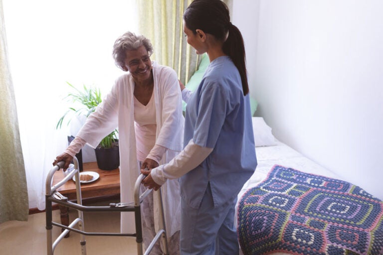 A woman in assisted living getting help in her apartment