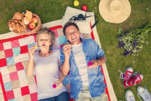 A couple enjoying the benefits of aging while picnicking with bubbles