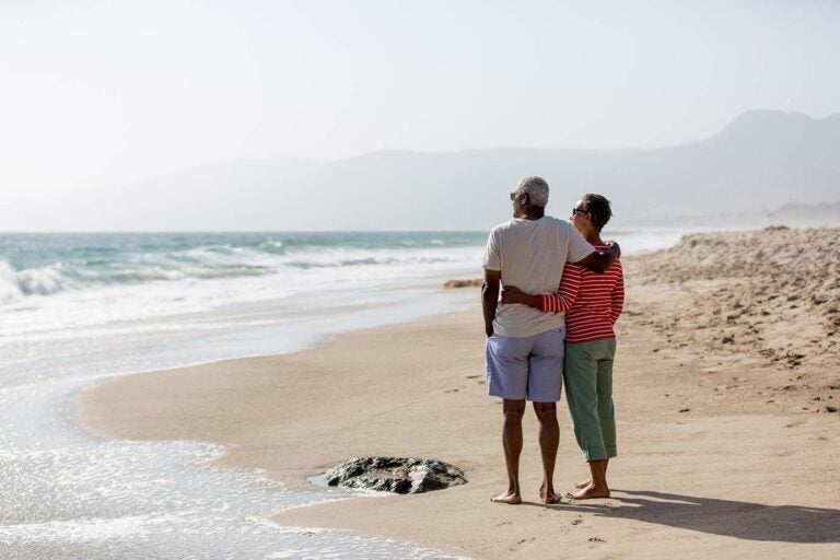 A couple on the beach contemplating the horizon and their estate plan