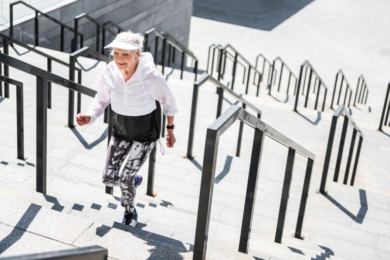 A woman running up a flight of stairs because she doesn't believe retirement is bad for your health