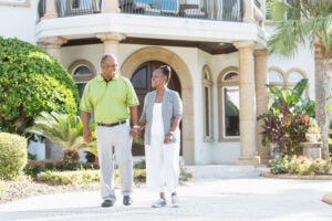 Two jumbo reverse mortgage borrowers in front of their home
