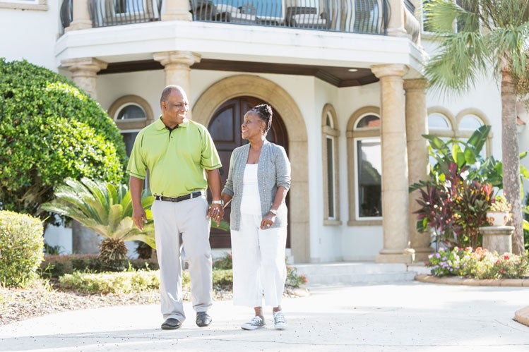 Two jumbo reverse mortgage borrowers in front of their home