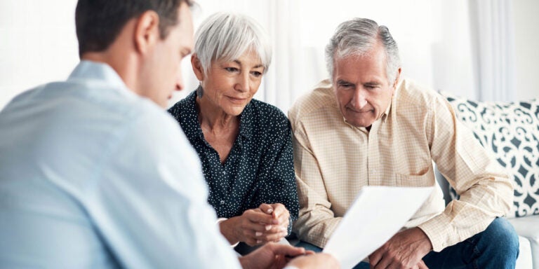 A couple reviewing a reverse mortgage with their financial advisor