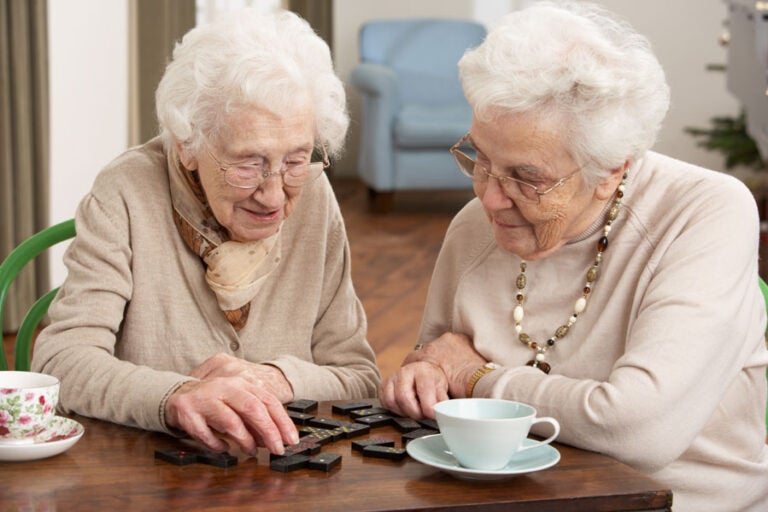 twp women play dominoes like weighing the pros and cons of annuities. what's the best move for you?