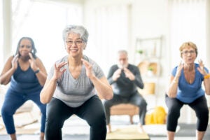People squatting in an exercise class - not a recommended technique for lowering RMDs