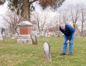 A man tracing his family tree in an old cemetary