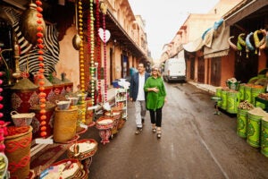 a couple stroll a market street on their trip of a lifetime